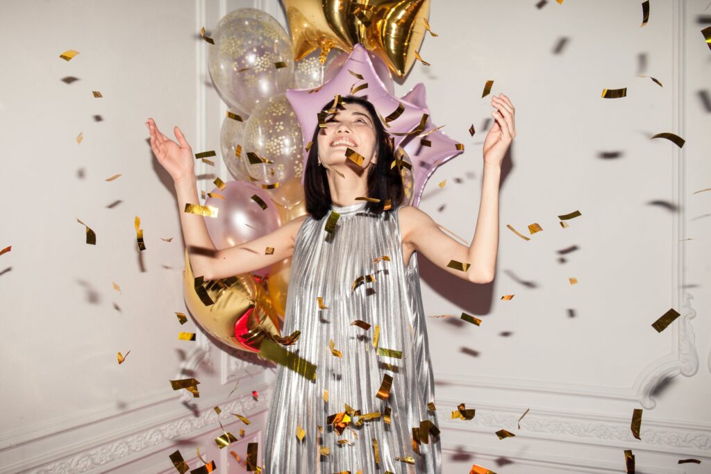 Glad kvinde med balloner og konfetti